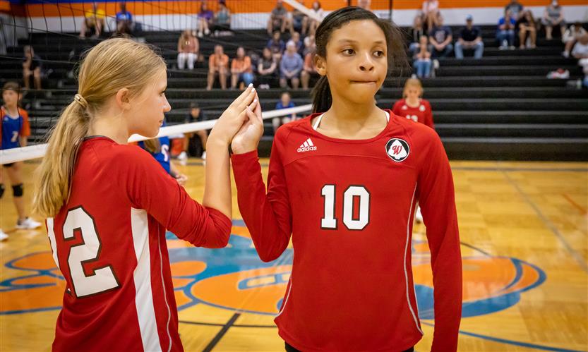 Two volleyball players prepare to substitute out